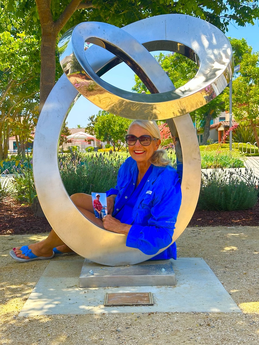 Dianne Van Hook poses with a sculpture dedicated to Roger's memory.